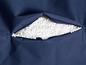 Blauwe stoffen hoes met open rits, gevuld met witte polystyreenkorrels.