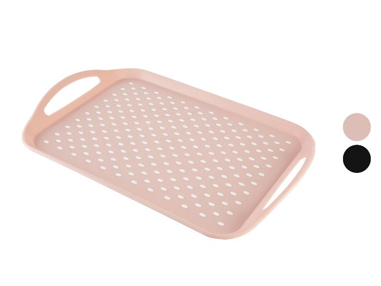 Roze dienblad met witte stippen en handvatten.