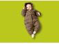 Baby in bruin gewatteerd skipak met capuchon, liggend op groene achtergrond.