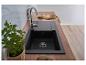 Moderne keuken met zwarte spoelbak, houten aanrechtblad en verse muntplant.