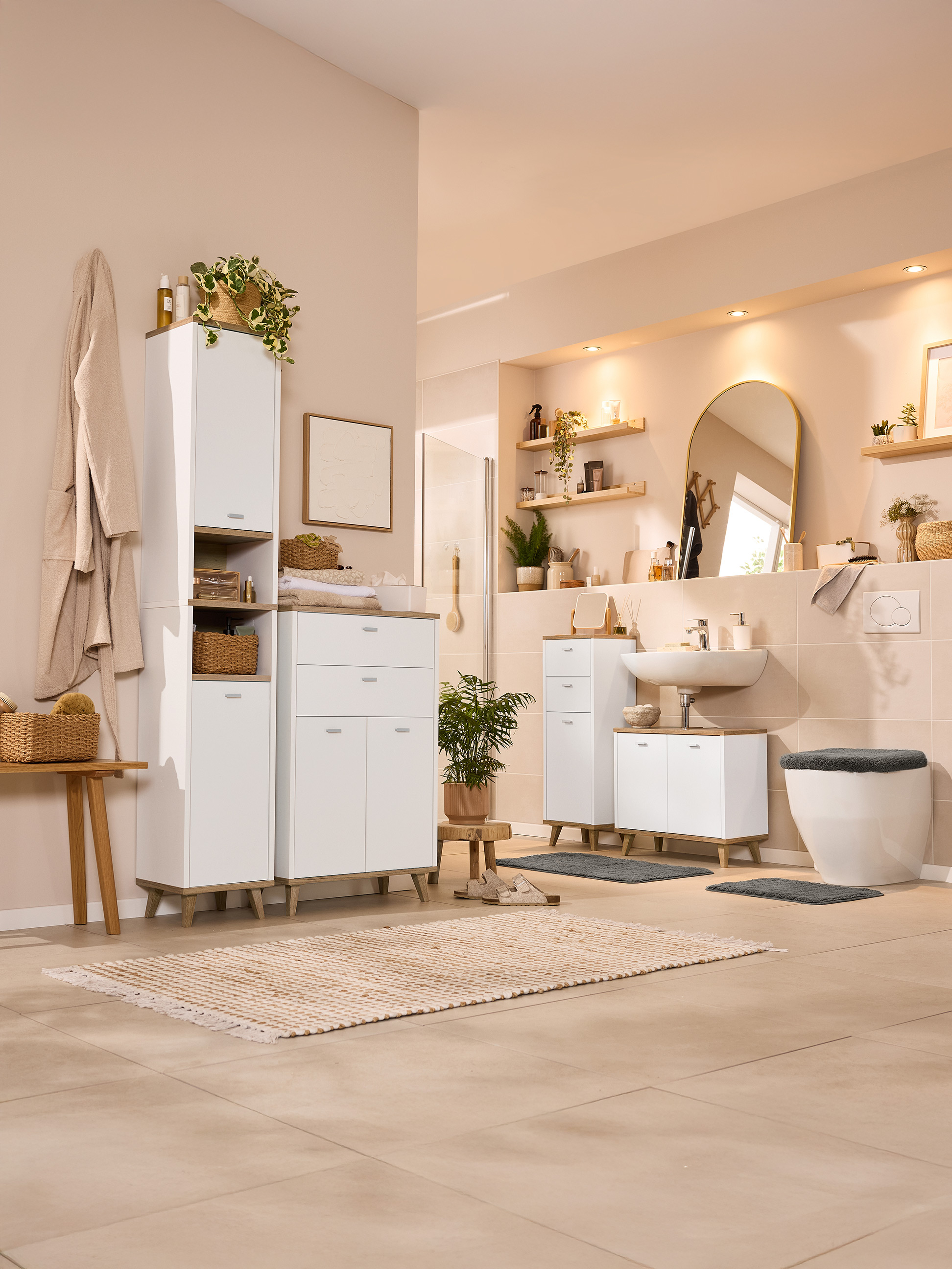 Lichte badkamer met wit meubilair, houten accenten en planten.