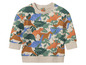 Een beige babytrui met dinosaurussenprint.