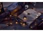 Halloween decoratie met spinnenlichtjes, oude boeken en schedels op een donkere tafel.