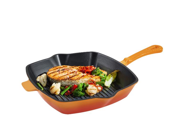 Een oranje vierkante grillpan met gegrilde zalm en groenten.