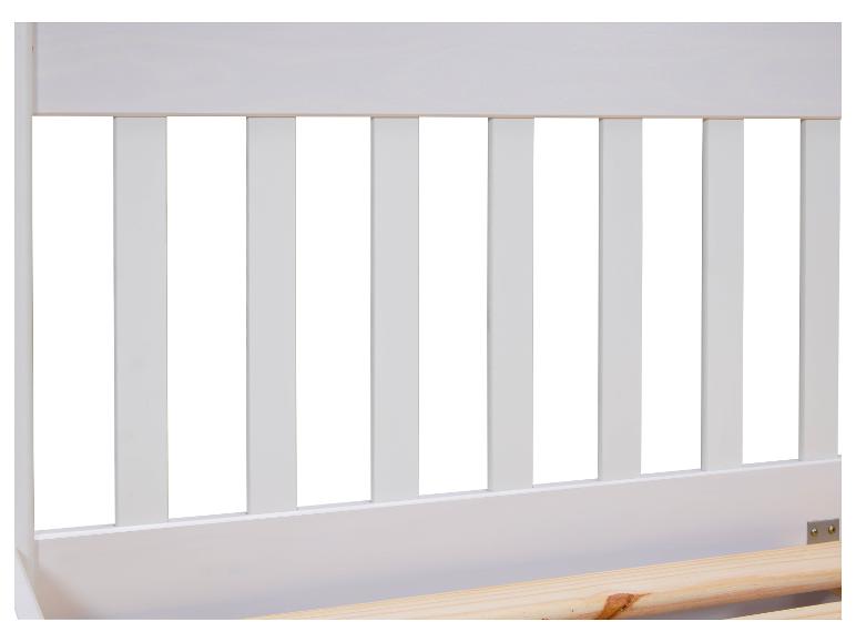 Detail van een wit houten bed met houten latten.