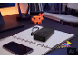 Zwarte powerbank op een notitieboek, met een smartphone en een gepixelde herten decoratie.