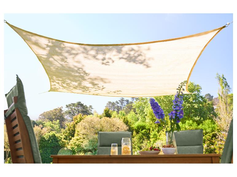 Beige schaduwdoek boven een houten tuintafel met drankjes en snacks.