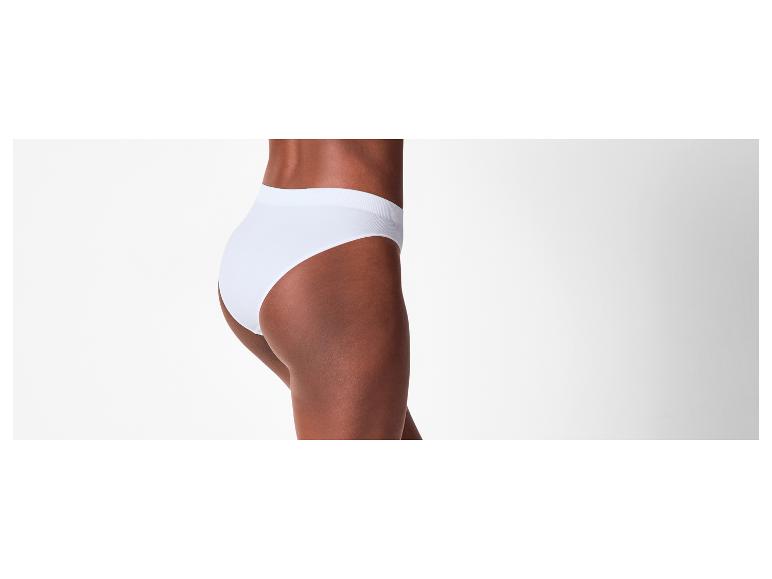 Een donkerhuidige vrouw draagt een witte slip, van opzij gezien.