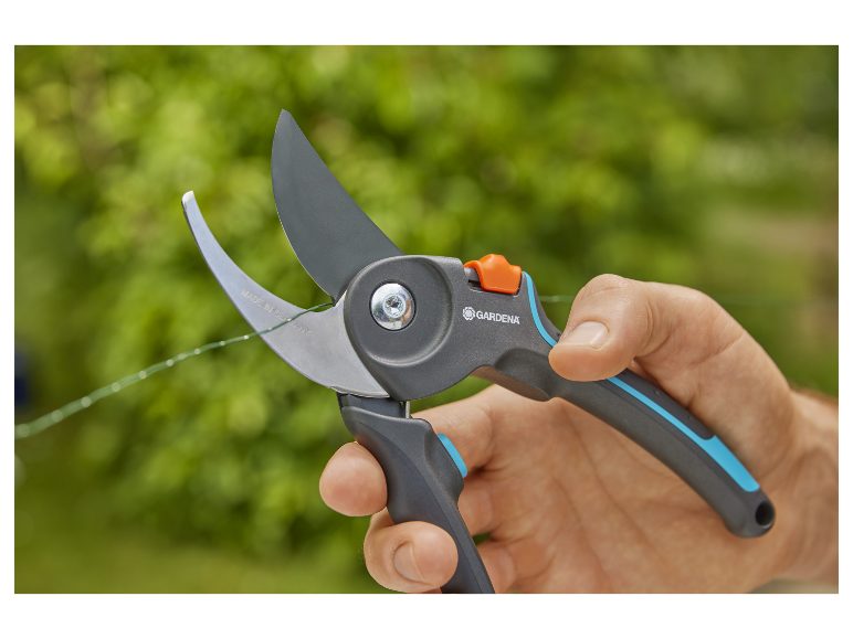 Gardena snoeischaar knipt tuindraad.