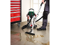 Nat- en droogzuiger die gemorst water van de vloer opzuigt.