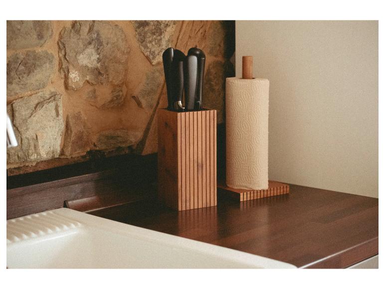 Bamboe messenblok en papieren handdoekenhouder op een aanrechtblad.