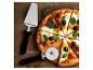 Pizza met tomaten, olijven en basilicum, met pizzasnijder en -schep op houten plank.