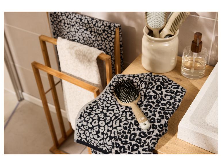 LIVARNO home badstof handdoeken met luipaardprint op een houten rek en wastafelmeubel