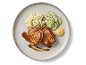 Gebakken varkenshaasmedaillons geserveerd met aardappelsalade, komkommersalade, jus en mosterd.