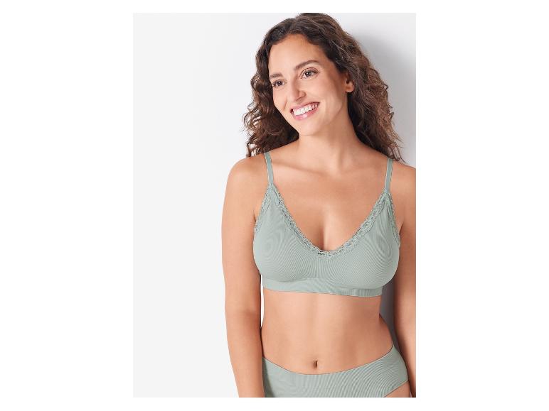 Een vrouw draagt een groene bh en slipje.