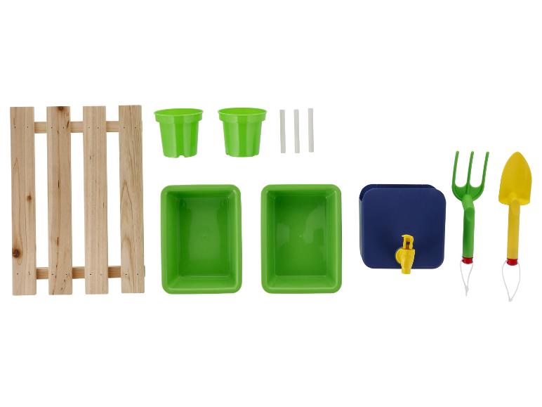 Tuinierset met houten hek, groene potten, bakjes, blauwe waterdispenser en gereedschap.
