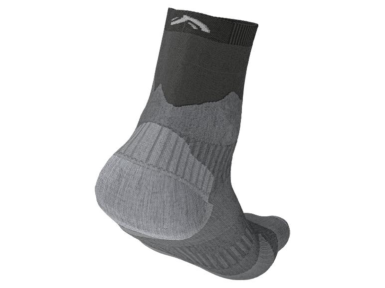 Grijze en zwarte sok met bergpatroon en logo op de manchet.
