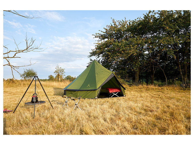 Een groene tent met een kookset en twee stoelen in een veld.