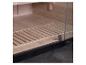Sauna-interieur met houten vloer en glazen deur, donkere vloer buiten.
