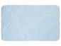 Een lichtblauwe badmat met een geometrisch patroon.