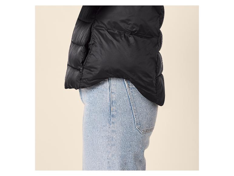 Zwarte gewatteerde jas en blauwe jeans