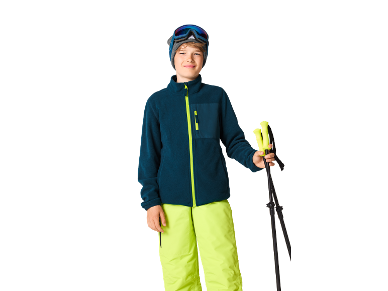 Jongen in skikleding met skistokken