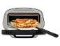 Elektrische pizzaoven met een versgebakken pizza op een pizzaschep.
