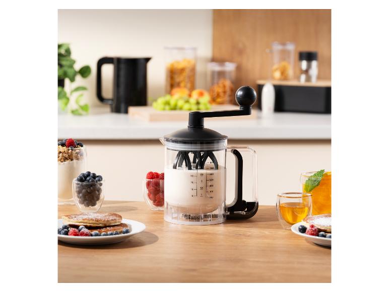 Beslagdispenser met slinger, pannenkoeken en bessen op een houten tafel.