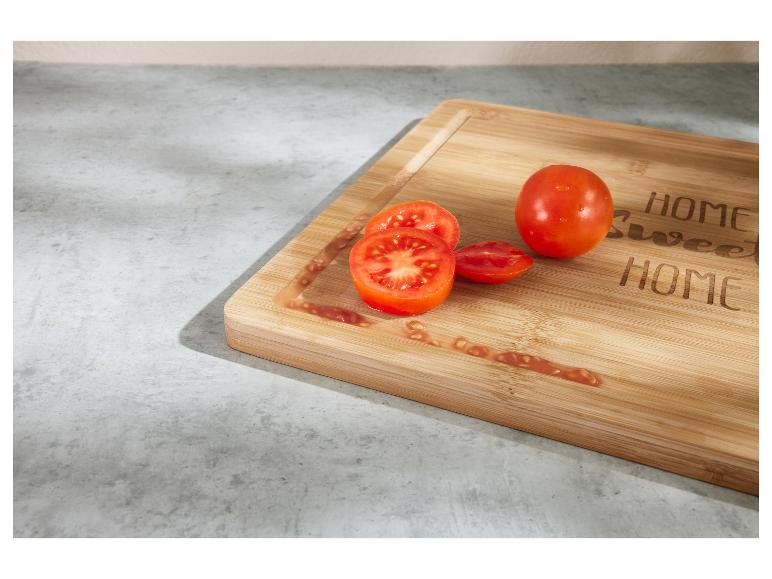 Verse tomaten op een bamboe snijplank met de tekst 'HOME Sweet HOME'.