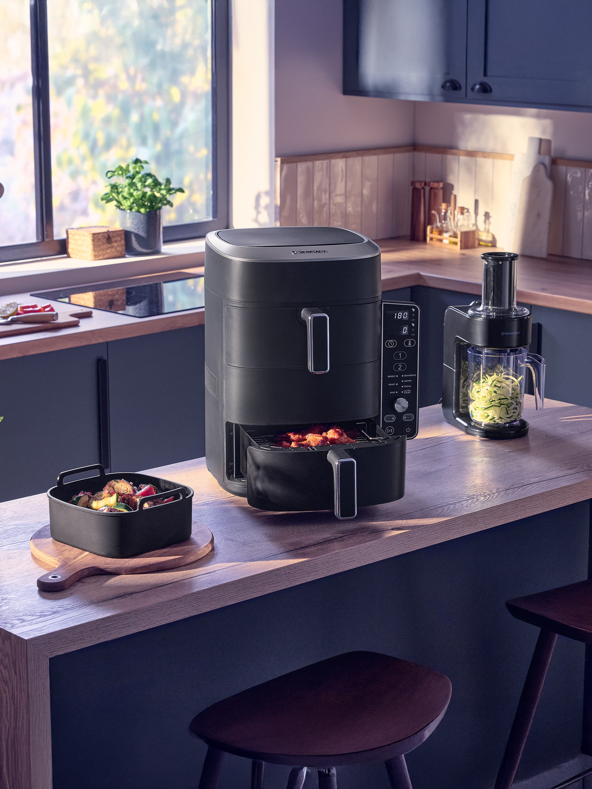 Airfryer en keukenmachine in een moderne keuken met bereid voedsel.