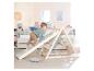 Peuter klimt op een houten klimrek in een kinderkamer met bed en decoratie.