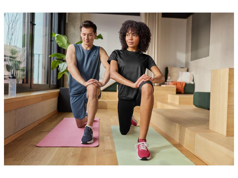 Man en vrouw in sportkleding doen lunges op oefenmatten.