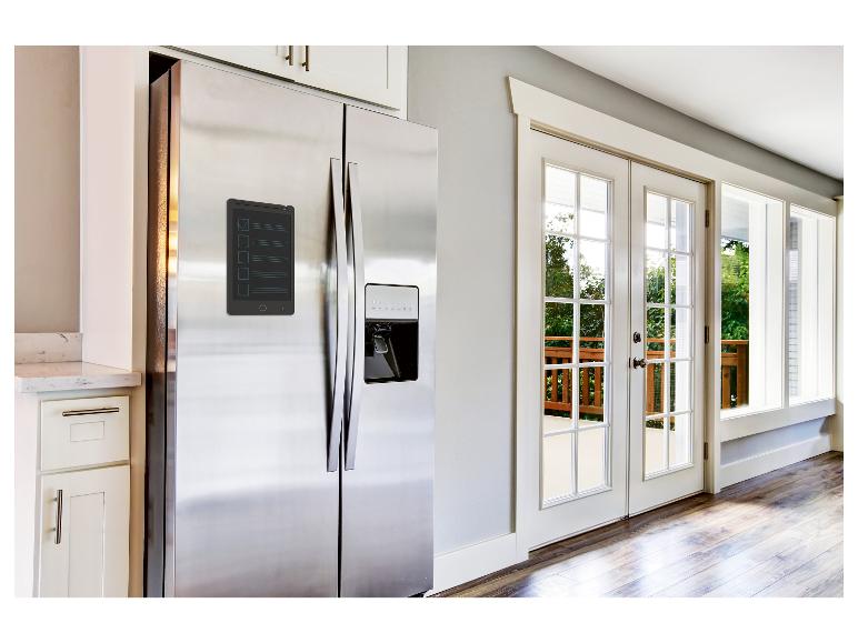 Een koelkast met een whiteboard ernaast in een keuken.