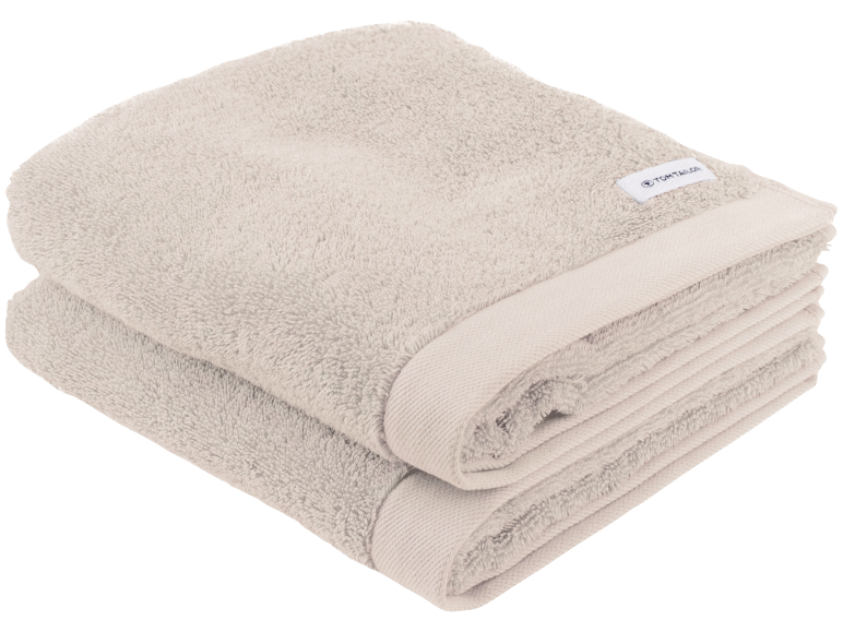 Twee gevouwen beige handdoeken, zacht en pluizig, met een subtiele rand.