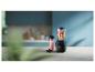 Zwarte blender met fruit en ijs, ernaast een roze smoothie en messen op tafel.