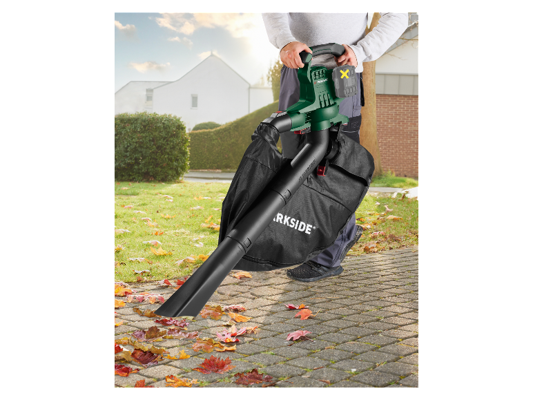 Een man gebruikt een Parkside bladblazer om herfstbladeren op te ruimen.