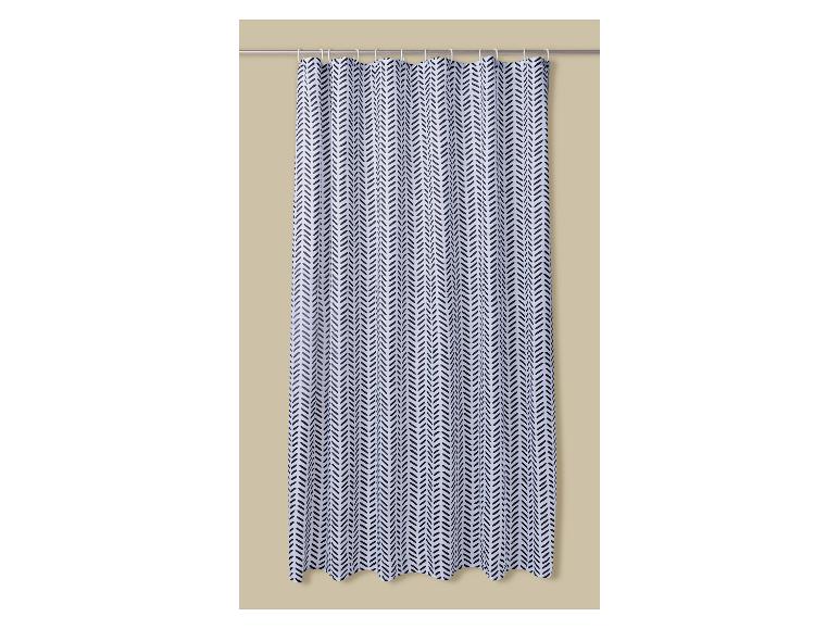 Wit douchegordijn met zwart chevronpatroon, hangend aan een metalen stang.