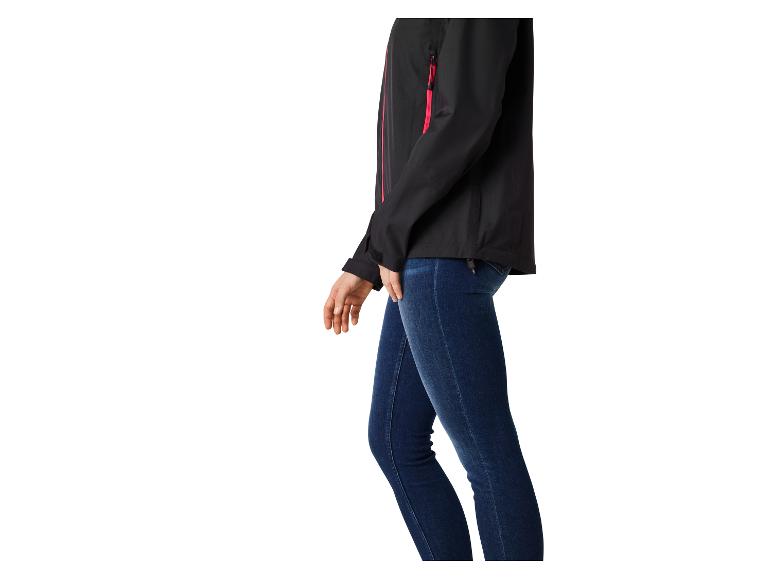 Zwarte softshell jas met rode ritsen en een donkerblauwe jeans