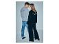 Man in grijze sweater en jeans, vrouw in zwarte sweater en wijde broek, met 'TRENEISE BLUE' op de rug.