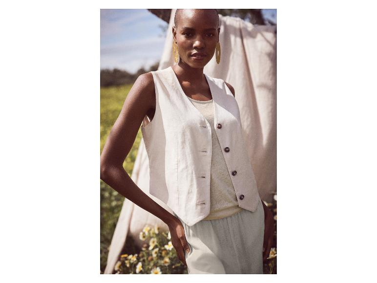 Model in lichtbeige linnen vest en broek.