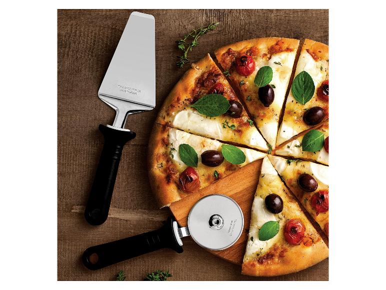 Pizza met tomaten, olijven en basilicum, met pizzasnijder en -schep op houten plank.