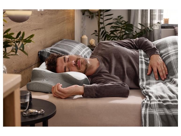 Man slaapt op een LIVARNO® Premium-neksteunkussen in een gezellige slaapkamer.