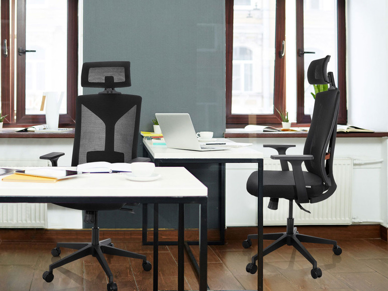 Twee zwarte bureaustoelen met hoofdsteun in een kantooromgeving.