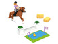 Een paardenspeelset met een ruiter, een paard, een hindernis, hooibalen en een vijver.