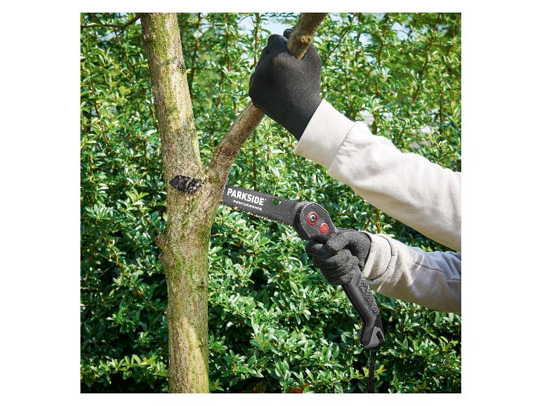 Gehandschoende persoon zaagt een boomtak met een Parkside Performance vouwzaag.