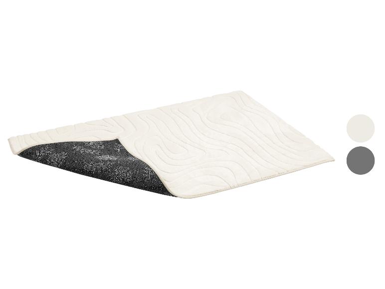 Beige badmat met houtnerf reliëf en antislip achterkant met bloemenpatroon.