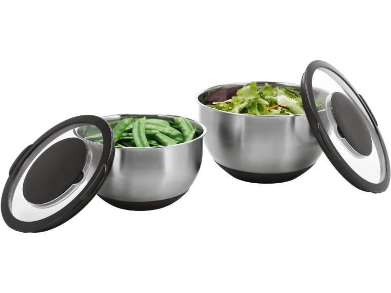 Twee roestvrijstalen kommen met deksels, één met sugar snaps en de andere met salade.