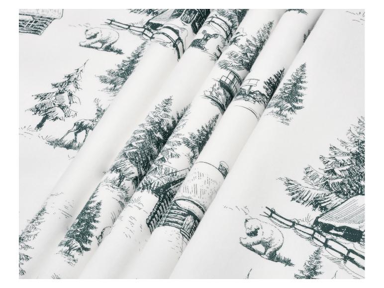 Witte stof met een donkergroene print van winterse taferelen, inclusief dieren en hutten.
