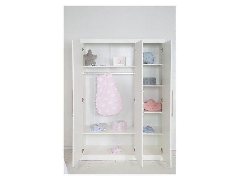 Een witte kledingkast met open deuren, gevuld met babykleding en accessoires.