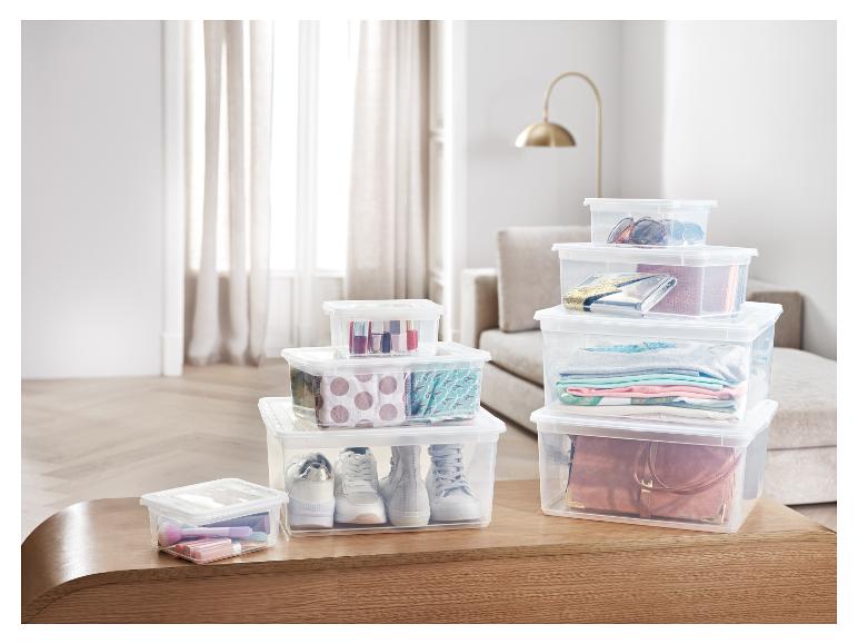 Transparante opbergdozen met kleding, schoenen en make-up.